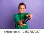 Photo of excited funky small boy wear green sweatshirt enjoying playing playstation isolated violet color background