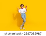 Photo of cheerful crazy girl wear trendy clothes speaking with friends social media telegram whatsup isolated on yellow color background