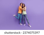 Full body photo two lesbians couple lovers brunettes cuddles together denim jeans basic t shirt advert isolated on purple color background