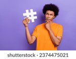 Photo of smart young man touch chin guess how create new tiktok media trend holding hashtag symbol isolated on violet color background