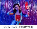 Small photo of Portrait of charming funky person hold smart phone make selfie show v-sign backdrop tinsel decor isolated on multicolor neon background