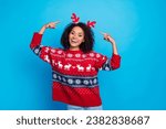 Photo of positive girl celebrating happy new year pointing fingers reindeer horns christmas vibe isolated on blue color background