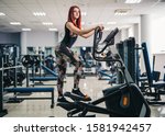 Small photo of Woman doing legs exercise on stair steppers machine, in gym. Full size photo, slim and fit figure concept