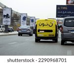 Small photo of Giza, Egypt, April 9 2023: Noon online shopping delivery yellow van to deliver a package, Arabic Translation (Noon.com express for fast delivery and easy return), Noon is an e-commerce company