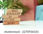 Wooden blocks with words 'What questions do you have?'.