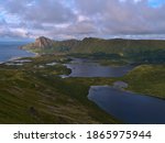 Stunning aerial panorama view of Bleiksvatnet lake, Bleikmorenen nature reserve and fishing village Bleik surrounded by mountains located on northwestern coast of Andøya island, Vesterålen, Norway.