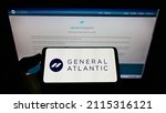 Small photo of Stuttgart, Germany - 06-06-2021: Person holding cellphone with logo of US private equity company General Atlantic on screen in front of business webpage. Focus on phone display. Unmodified photo.