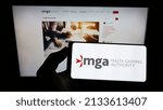 Small photo of Stuttgart, Germany - 01-22-2022: Person holding cellphone with logo of Maltese institution Malta Gaming Authority (MGA) on screen in front of webpage. Focus on phone display. Unmodified photo.