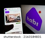 Small photo of Stuttgart, Germany - 05-20-2022: Person holding smartphone with webpage of Colombian company INVERSIONES MCN S.A.S (Habi) on screen with logo. Focus on center of phone display. Unmodified photo.