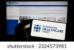 Small photo of Stuttgart, Germany - 06-18-2023: Person holding cellphone with logo of real estate company Diversified Healthcare Trust on screen in front of webpage. Focus on phone display. Unmodified photo.