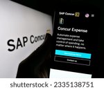 Small photo of Stuttgart, Germany - 07-11-2023: Person holding cellphone with website of expense management software SAP Concur on screen in front of logo. Focus on center of phone display. Unmodified photo.