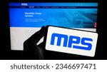 Small photo of Stuttgart, Germany - 08-05-2023: Person holding smartphone with logo of US company Monolithic Power Systems Inc. (MPS) on screen in front of website. Focus on phone display. Unmodified photo.