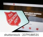 Small photo of Stuttgart, Germany - 10-09-2023: Cellphone with logo of Protestant charity organization The Salvation Army (TSA) in front of website. Focus on center of phone display. Unmodified photo.