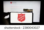 Small photo of Stuttgart, Germany - 10-09-2023: Person holding cellphone with logo of Protestant charity organization The Salvation Army (TSA) in front of webpage. Focus on phone display. Unmodified photo.