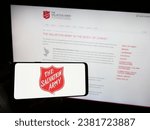 Small photo of Stuttgart, Germany - 10-09-2023: Person holding smartphone with logo of Protestant charity organization The Salvation Army (TSA) in front of website. Focus on phone display. Unmodified photo.