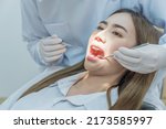 Small photo of Caucasian male dentist using medical instruments for oral care check up. Young woman receive take care from professional dentist for cavities and gum disease in tooth care program of dental clinic.