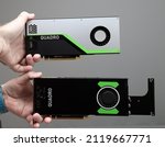 Small photo of Paris, France - Mar 28, 2019: Two people - senior and young engineer hands pov holding looking at two new GPU Nvidia Quadro RTX 4000 RTX 5000 video cards based on the Turing microarchitecture, and