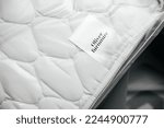 Small photo of Copenhagen, Denmark - Oct 25, 2022: Detail on the etiquette of a new baby children luxury mattress for crib with logotype insignia of Oliver Furniture
