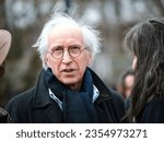 Small photo of Strasbourg, France - Mar 29, 2023: Elderly man poses in front of ECHR, joined by environmental advocates holding placards and paper flowers, conveying a strong sustainability message