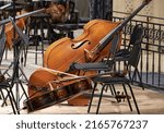 Small photo of A cello lies on stage next to classical instruments during the intermission of a symphony concert