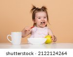 Small photo of Baby child eating food. Happy smiling baby girl with spoon eats itself.