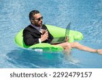 Small photo of Summer business dreams. Business man in suit floating with cocktail and laptop in swimming pool. Summer business vacation. Funny crazy businessman rest in formal wear in pool. Hot summer business.