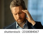 Man with sinus headache, tension or cluster headache, close up portrait. Head pain concept. Cephalalgia and migraine. Migraine symptoms. Chronic headaches. Headache triggers.