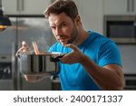 Small photo of Chef cook cooking soup at kitchen. Chef cook prepares a soup bowl with soup pot. Soups recipe. Chef cooking soup in modern kitchen. Mature chef man standing in kitchen, preparing food.