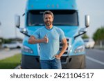 Small photo of Men driver near lorry truck. Man owner truck driver in t-shirt near truck. Handsome middle aged man trucker trucking owner. Semi trailer, semi trucks. Handsome man posing in front of truck.