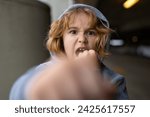 Small photo of Aggressive child. Aggression kid boy fighting on street. Angry aggression kid with fist. Aggression fight kid. Bullied, physical abuse, children fighting. Aggression little boy. Kids bad behavioral.