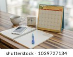 Notebook with pen diary clock smartphone coffee on table with March 2018 calendar at office work place. Planning scheduling agenda, Event, organizer writing detail of plan for 2018. Calendar concept.