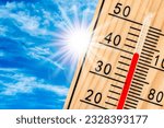 Small photo of thermometer shows high temperature in summer heat with dryness and lack of water in field