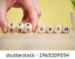 Small photo of Concept synonym and antonym on wooden cubes