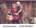 Nice caucasian people enjoy leisure outdoor both on a single bike lauhing like crazy. together funny moments at home outside. vintage filter and colors for joyful and laugh concept