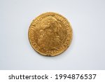 Old large gold coin from the year 1765 with the image of Carolus III on a white background.