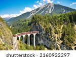 Small photo of Landwasser viaduct in the Davos mountains near Filisur. Beautiful old stone bridge with a moving train. Spring Time.