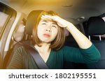 Small photo of Asian woman driving car with problem short sight eye vision and blur with sunny light