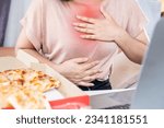 Small photo of woman suffering from chest pain from heatburn caused by acid reflux after eating junk food pizza