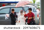 Small photo of Sarawak, Malaysia – March 1, 2013: The photo showing portrait of modern Chinese Wedding culture that the bride was covered by red parasol so which is a belief to ward off any evil elements or spirits.