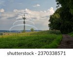 Small photo of Mobile radio tower in the open nature, with fields, forests and meadows. Slightly cloudy, beautifully textured sky. Virtual icons regarding data connections and access to cloud data, phone, email.