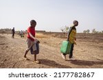 Small photo of African children fetching water from a village pump; lack of houshold taps and child labour in developing countries
