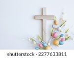 Cross with Easter eggs on a white background with copy space 