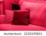 Small photo of Image toned in pantone color of year 2023 viva magenta. cushions on cozy red sofa. Pillows on casual couch in the living room