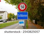 Close-up of traffic sign speed limit 50 and sign of City of Schlieren with text Energy City Gold at Swiss City of Zürich district Altstetten. Photo taken November 11th, 2024, Zurich, Switzerland.