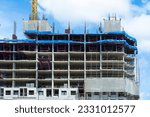Construction site background. Hoisting cranes and new multi-storey buildings. Industrial background. Building construction site work against blue sky.monolithic technology.