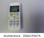 Small photo of Air conditioner remote control on white background and negatif space.