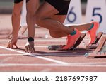 Small photo of Man in a start block on an athletic track. A sprinter in a track and field race is poised at the starting line waiting for the start