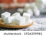 sugar cubes on black backround. Sugar is unhealthy nutrition and leads to obesity, diabetes, dental care