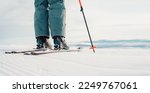 Small photo of Woman in skiing clothes with helmet and ski googles on her head with ski sticks. Winter weather on the slopes. Mountain and enjoying view. Alpine skier. Winter sport. Ski touring