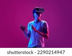 Small photo of Escape from reality. One young guy wearing VR headset glasses over pink neon background. Youth and virtual lifestyle of future. Concept of games, modern, digitalization and technology